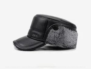 Side view of men's leather flat cap with grey faux fur earflaps and metal logo detail