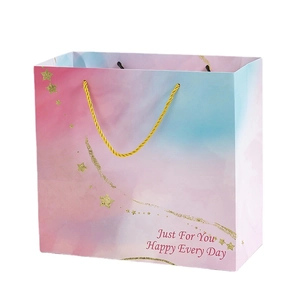 Pink and purple gradient gift bag with golden stars and twisted handles for any occasion