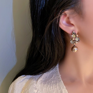 Vintage floral drop earrings with pearls and crystals shown on model in a close-up view