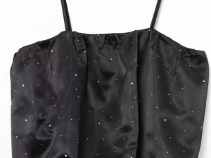 Détail d'un caraco en satin noir avec encolure plissée et strass argentés étincelants