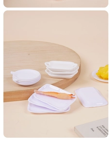Macro detail of miniature white ceramic-style trays and plates for DIY dollhouse scenes