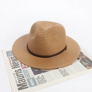 Detailed close-up of straw sun hat weaving texture with dark brown decorative band
