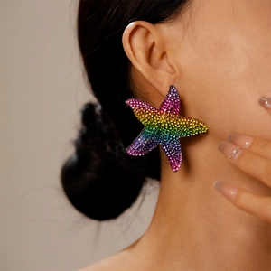 Detailansicht der Regenbogen-Strass-Seestern-Ohrringe getragen im Strandurlaub-Stil