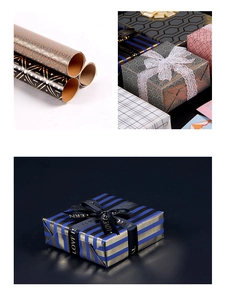 Close-up of black and gold geometric gift wrapping paper rolls with decorative ribbons