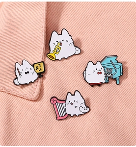Detail of four cute cartoon cat enamel pins playing musical instruments on pink fabric