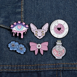 Set di 6 spille smaltate pastel goth con gatto e motivi occhi su sfondo di jeans blu