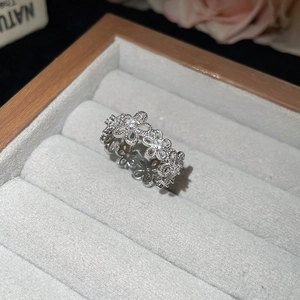 Detailed view of silver flower ring with zircons resting in a velvet jewelry box