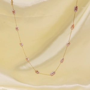 Elegant 14K gold-plated necklace with irregular natural pink pearls on gold silk background