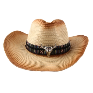 Western style straw cowboy hat with ethnic band and silver bull head emblem on white backdrop