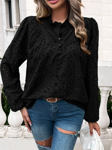 Detail of black long sleeve blouse with hollow-out embroidery and puff sleeves