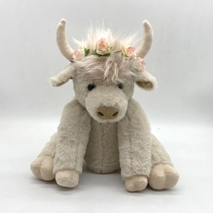Detailed view of plush Highland Cow with floral crown accessory on white background