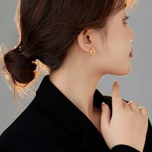Elegant gold double hoop U-shaped earrings worn by a model in a minimalist French style