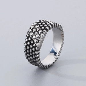 Macro detail of men's stainless steel ring with beaded texture and crystal stones inlay