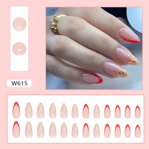 Almond-shaped press-on nails in nude pink with red French tips and gold foil accents