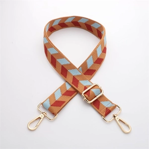 Detail of adjustable ethnic style wide strap with geometric patterns and gold metal clips