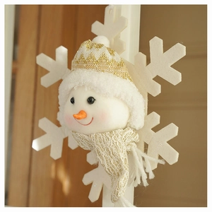 Close-up of plush snowman ornament with knitted hat and felt snowflake decoration