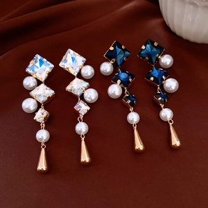 Detail of vintage geometric drop earrings with crystals, pearls and gold teardrops