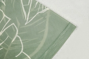 Macro detail of breathable sage green mesh fabric with white leaf prints and fine stitching