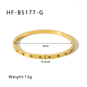 Detailed view of gold bangle dimensions 6cm diameter 0.4cm width with green stones