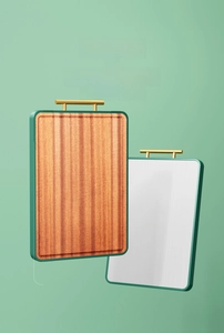 Dual-sided cutting board with ebony wood and stainless steel surfaces and gold handle