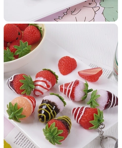 Detailed view of realistic strawberry pendants with colorful chocolate coating and metal ring