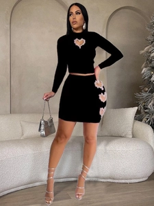 Women's black two-piece skirt set with heart cut-outs and white lace trim detail