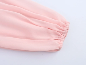 Close-up of pink chiffon dress lantern sleeve with elastic cuff and pleated texture