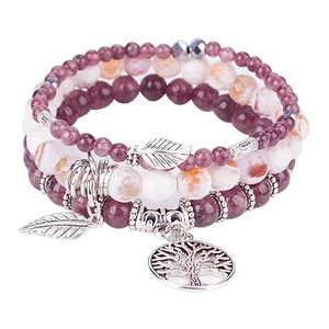 Close-up of tree of life and feather charms on bohemian turquoise beaded bracelets set