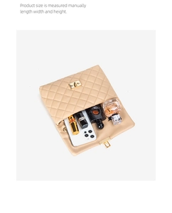 Top view of beige quilted crossbody bag interior showing phone, lipstick and perfume