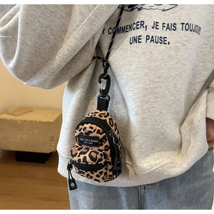 Detail view of mini leopard print crossbody bag with dual zippers and fashion label