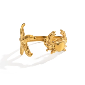 Détail macro d'une bague dorée thème marin avec motifs d'étoile de mer et de crabe