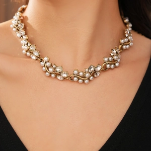 Close-up of vintage oval pearl necklace with diamonds and antique gold chain on model