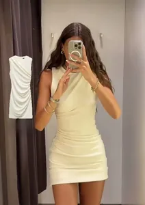Détail d'une robe moulante sans manches blanc cassé avec texture plissée sur le côté
