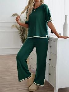 Detail of dark green knit lounge set featuring white stripe accents on short sleeves and pants