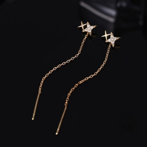 Elegant gold double star tassel earrings with white zircon on black mirror background