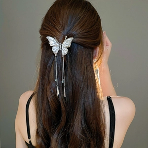 Elegant silver butterfly hair claw with rhinestone tassels worn on back of hair