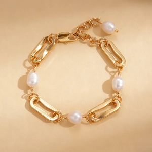 Macro detail of 18k gold plated chain bracelet with elegant pearls on leather texture