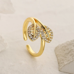 Macro shot of 18K gold plated leaf ring with cubic zirconia on natural stone