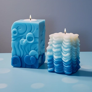 Bougies artistiques bleues avec motif relief et texture ondulée en état allumé