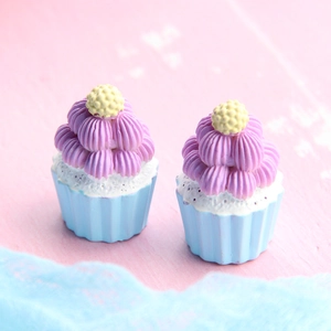 Miniature blue and purple resin cupcakes on a pink background for DIY crafts
