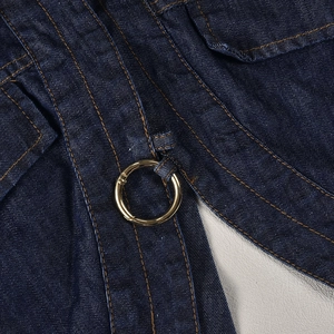 Detailed close-up of dark blue denim fabric texture and polished gold metal button