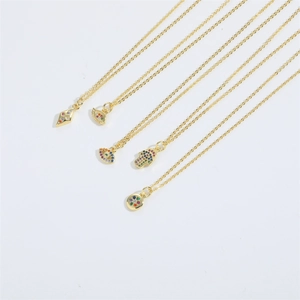 Collection of gold chains with colorful zircon pendants like Evil Eye and Hamsa Hand