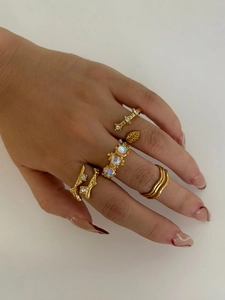 Close-up of bohemian gold ring set featuring moonstone and vintage geometric leaf designs