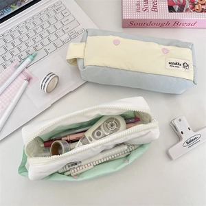 Overhead view of large capacity macaron canvas pencil bags with colorful stationery