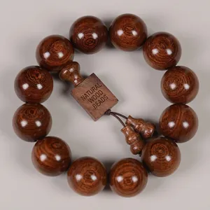 Macro shot of 13 large dark brown sandalwood beads showing fine cat-eye wood grain