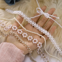 Close-up of pearl necklaces with butterfly and flower charms on white fur