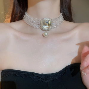 Close-up of multi-layer pearl choker with a square crystal pendant and diamond accents