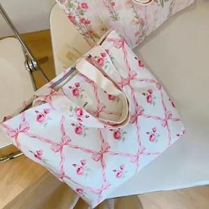 Sac fourre-tout en toile à fleurs avec nœuds roses et boutons de rose sur fond blanc
