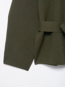 Detailaufnahme der dunkelolivgrünen Strickstruktur mit passendem Taillengürtel