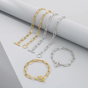 Dettagli di braccialetti a graffetta in oro e argento con texture intrecciate e chiusura a T